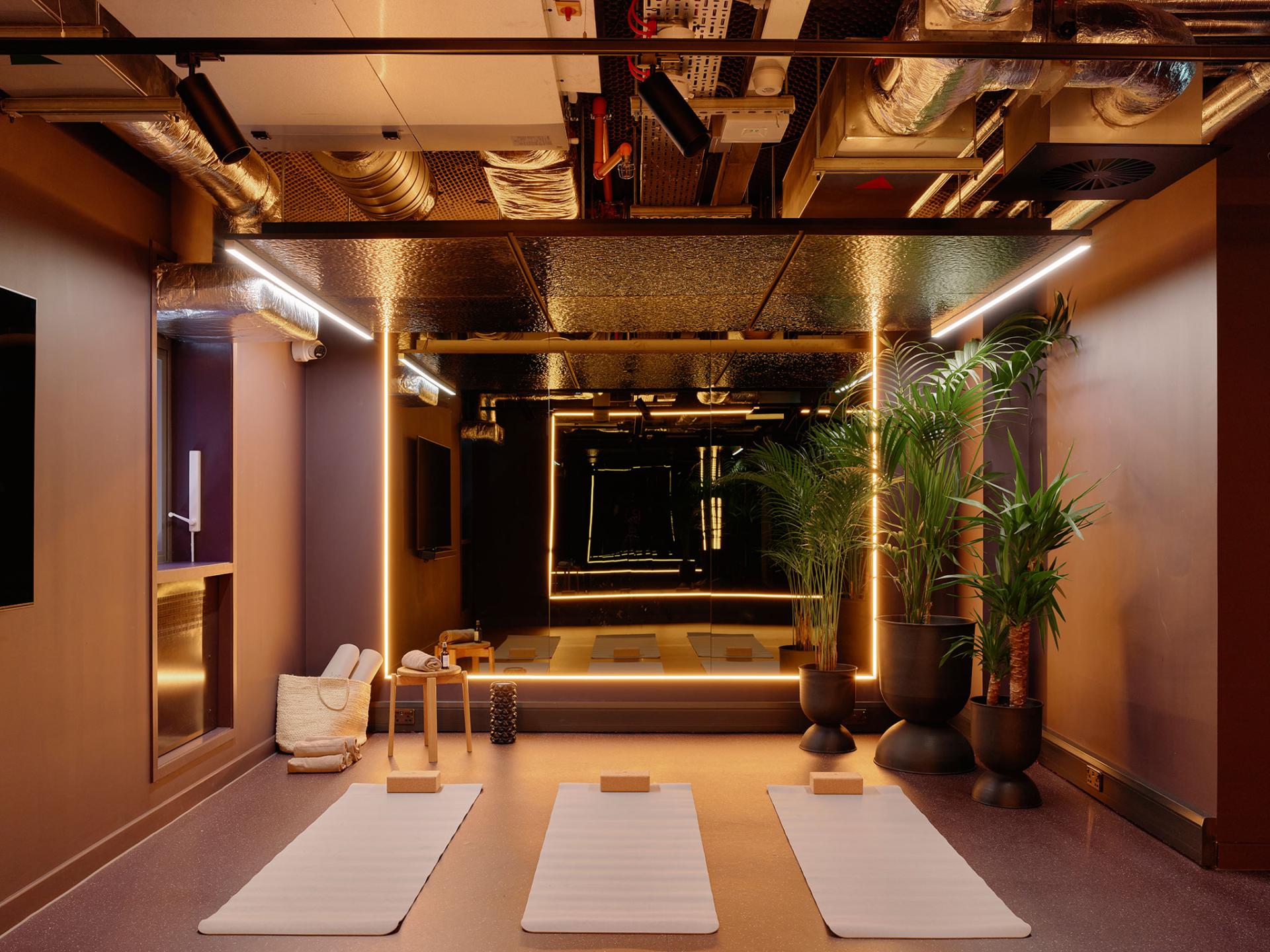 Modern wellness studio featuring yoga mats, ambient lighting, plants, and stylish design elements in PBSA, Edinburgh.