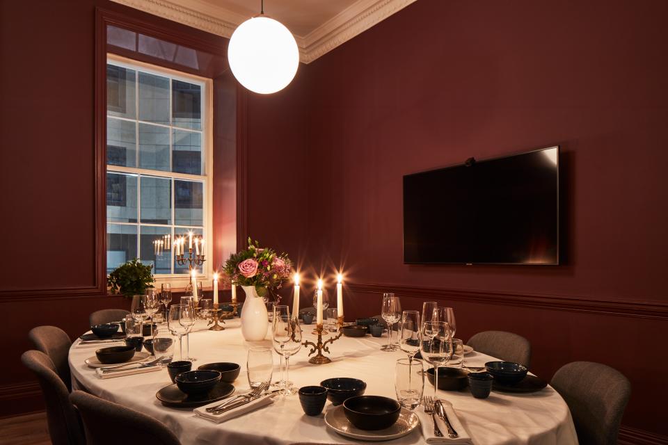 Elegant co-working space designed by Studioshaw, featuring a dining setup with candles, flowers, and modern decor.