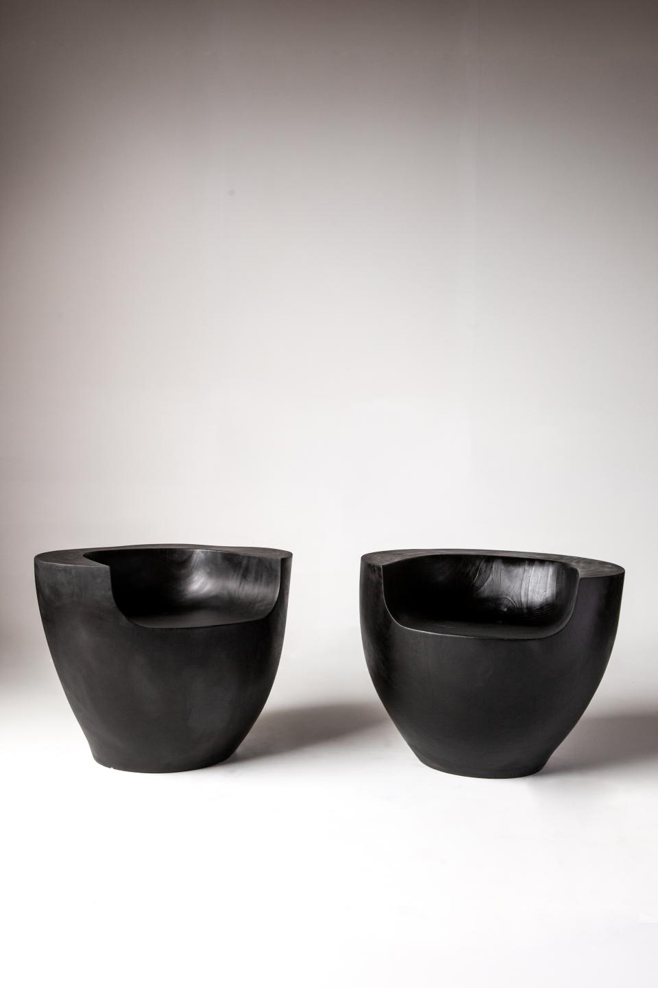 Modern black sculptural chairs displayed against a minimalistic background, showcasing Reynold Rodriguez's artistic design in "Before the Fantastic."