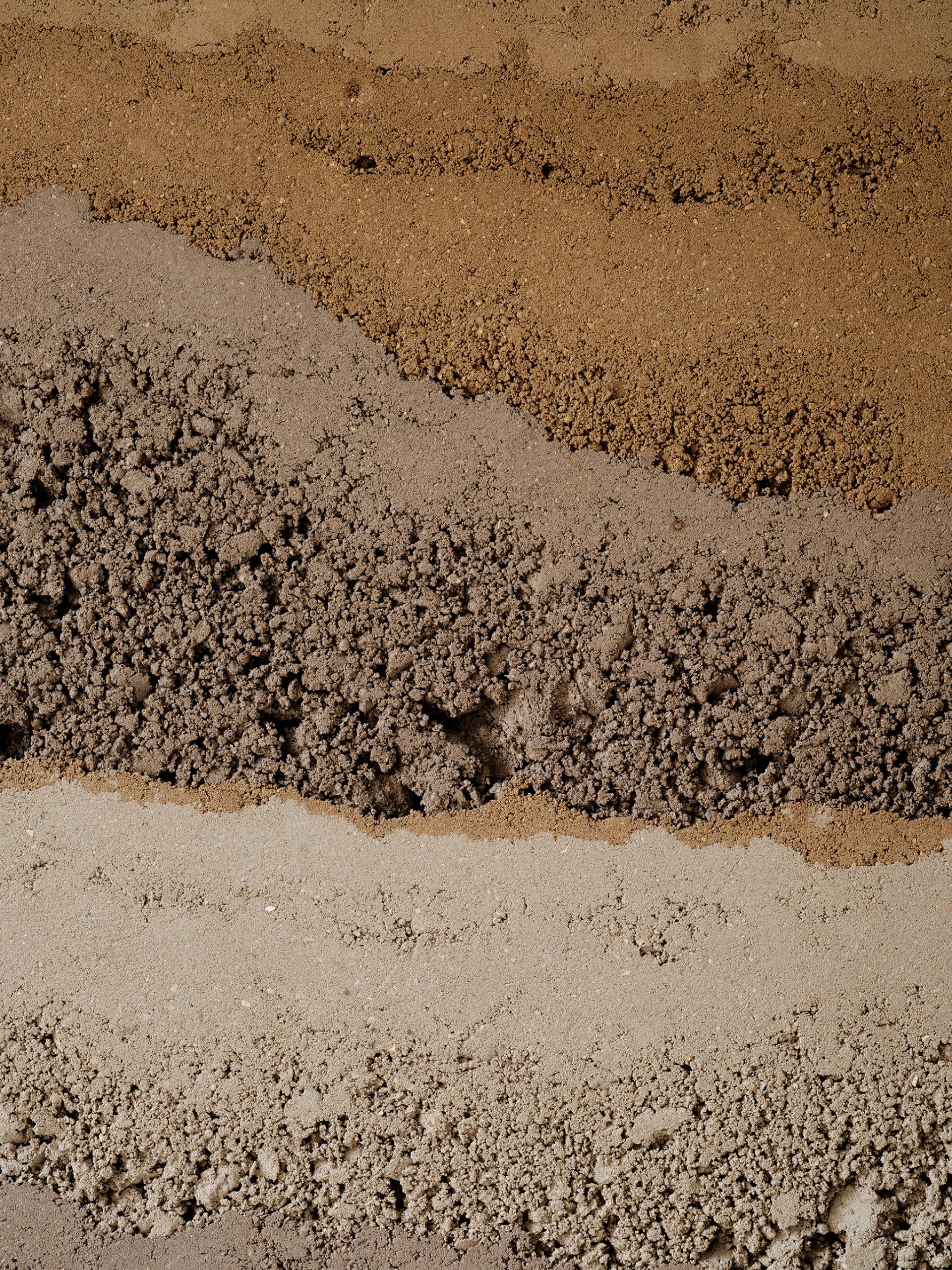 Layers of natural earth materials showcasing Clayworks' sustainable, low carbon wall finishes inspired by rammed earth aesthetics.