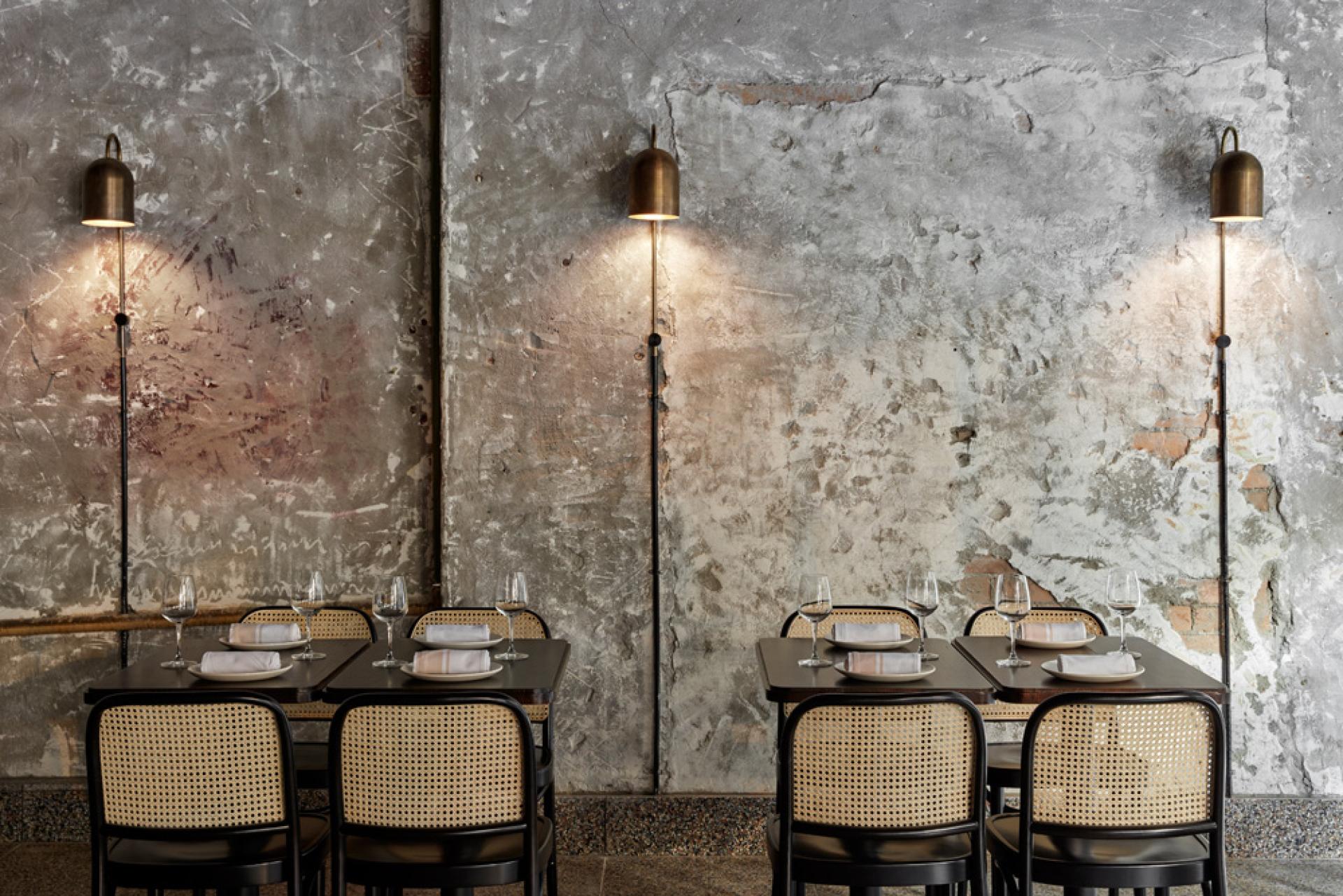 Stylish interior of Pentolina restaurant showcasing tables, elegant lighting, and rustic concrete walls inspired by Italian pasta bars.