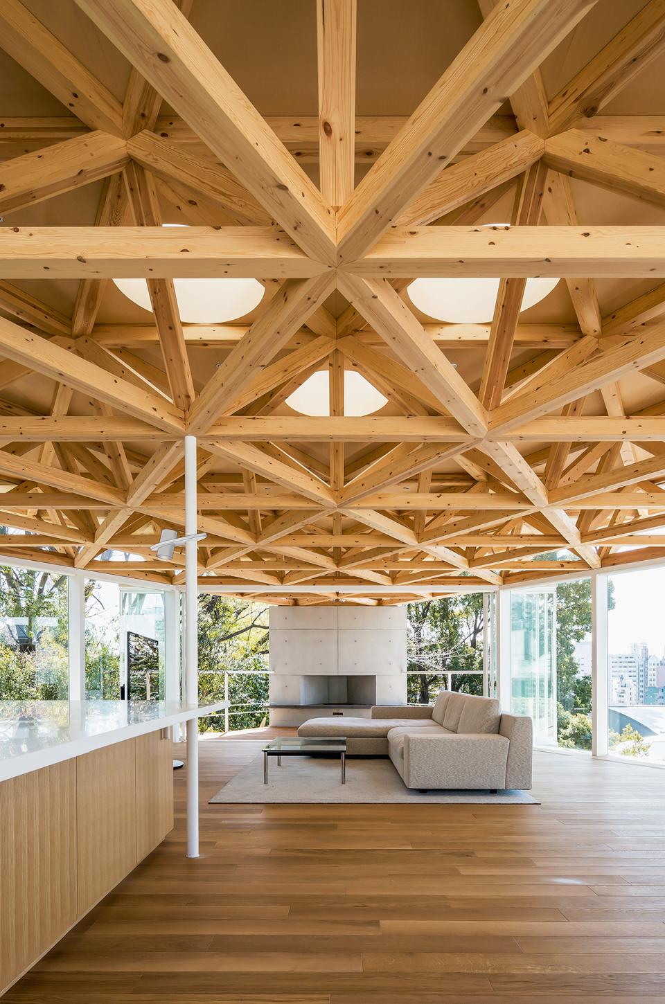 Modern living room featuring a striking wooden ceiling, large windows, and minimalist furnishings for contemporary home design.