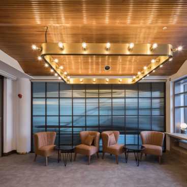 Modern interior of Belgrade Theatre featuring stylish seating, ambient lighting, and large windows illuminating the space.