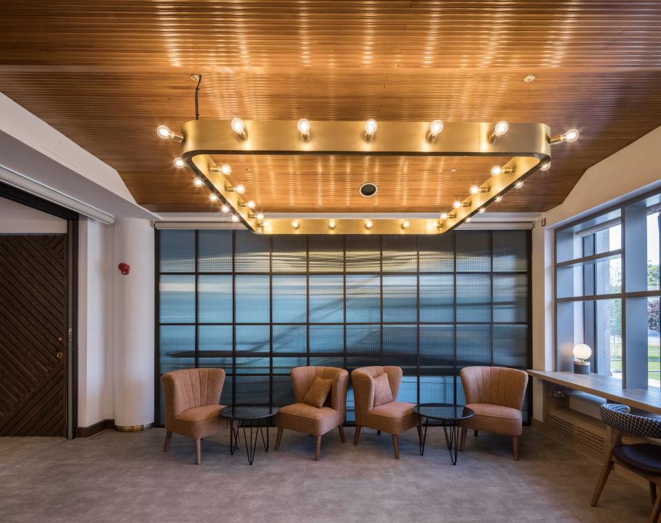 Modern interior of Belgrade Theatre featuring stylish seating, ambient lighting, and large windows illuminating the space.
