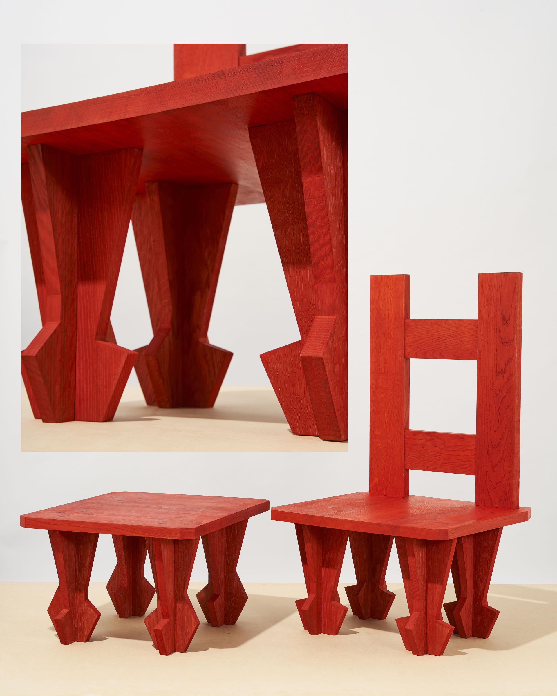 Bold red woodworking showcasing a chair and side table designed by Dharma Taylor and Paul Smith, blending traditional craftsmanship and modern aesthetics.