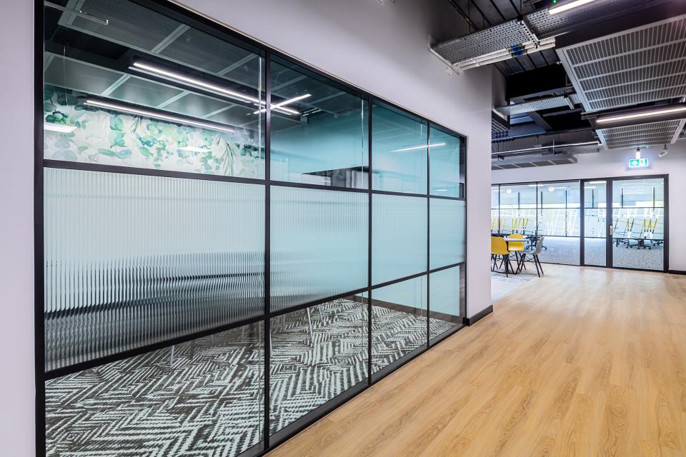 Modern office interior featuring glass partitions and vibrant workspace design at The Bee House, Milton Park, Oxfordshire.