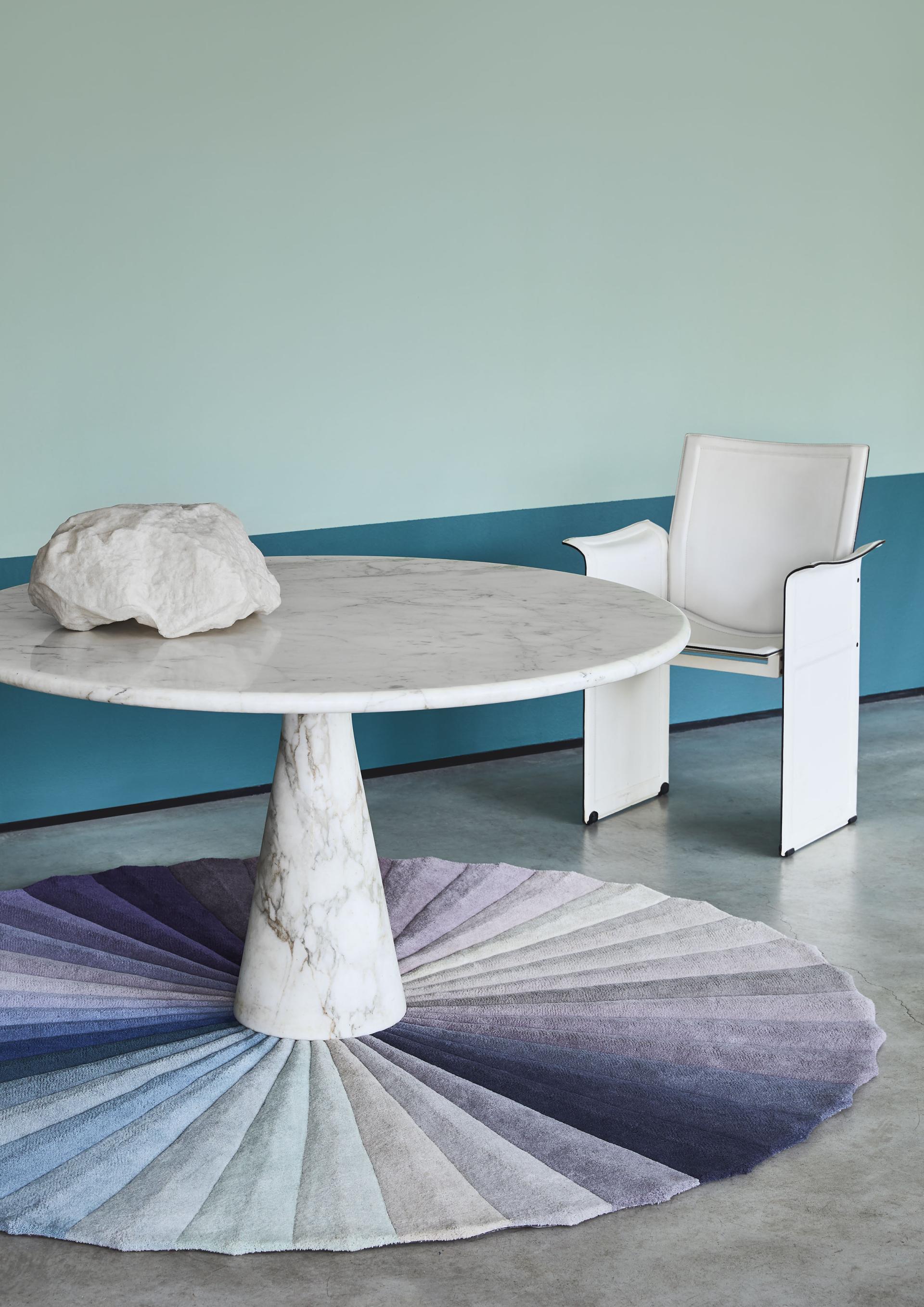 Elegant marble table with a textured rug, showcasing a calming color palette and modern design elements in a serene setting.