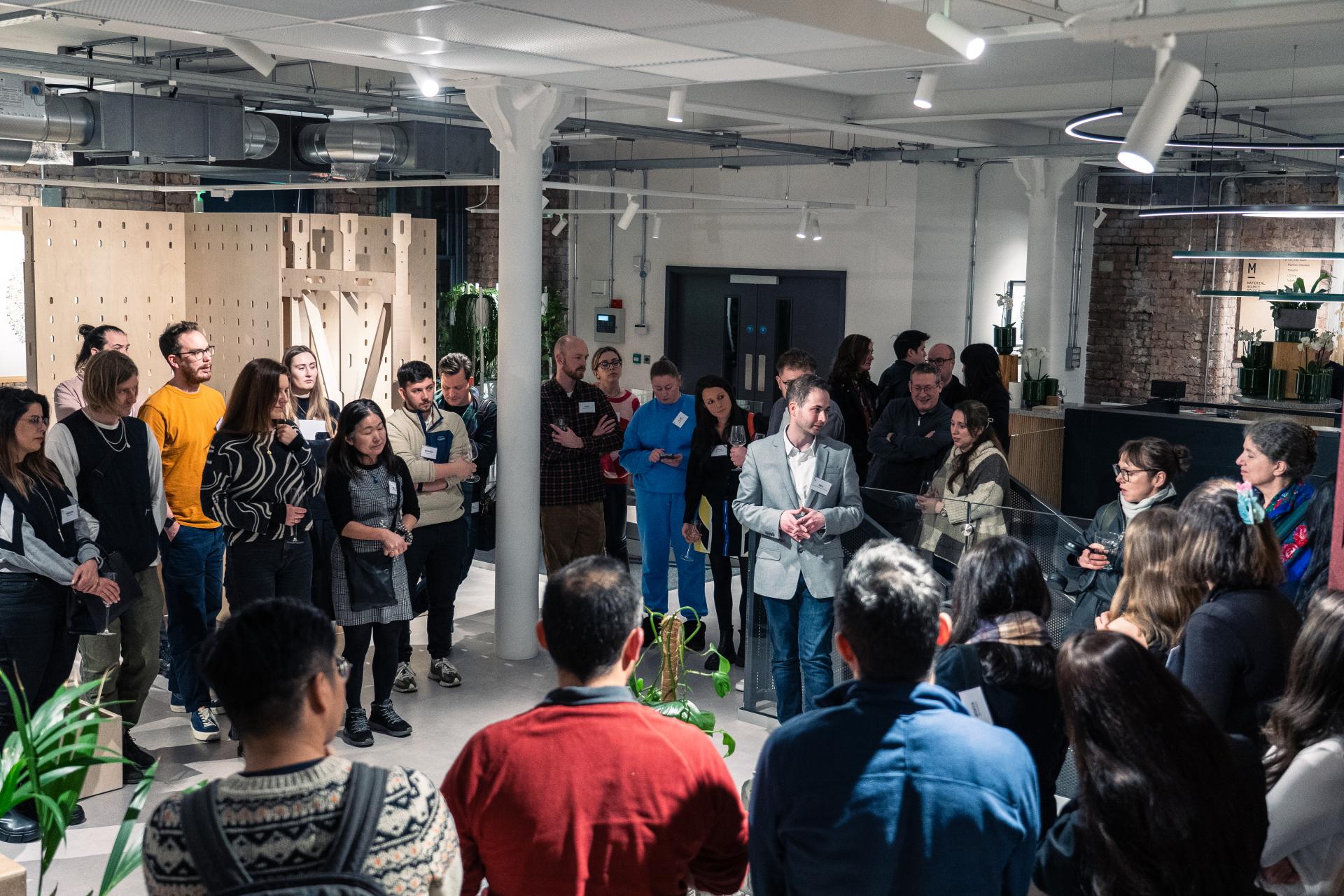 Crowd engaged in discussion at Full Circle Concrete exhibition, highlighting sustainable 3D printing innovations and future developments.