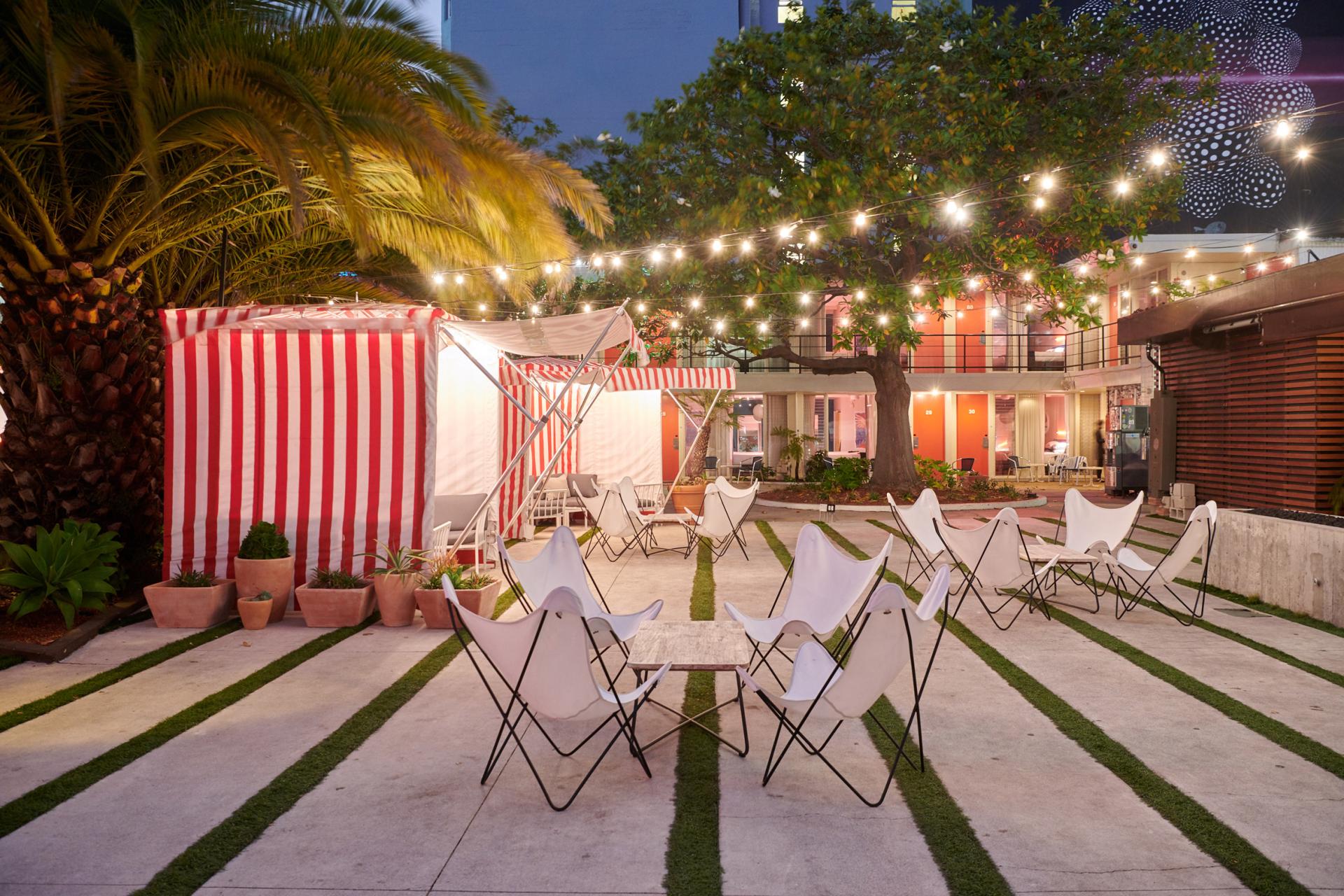 Charming outdoor area of the Phoenix Hotel featuring butterfly chairs, string lights, and colorful striped tents.