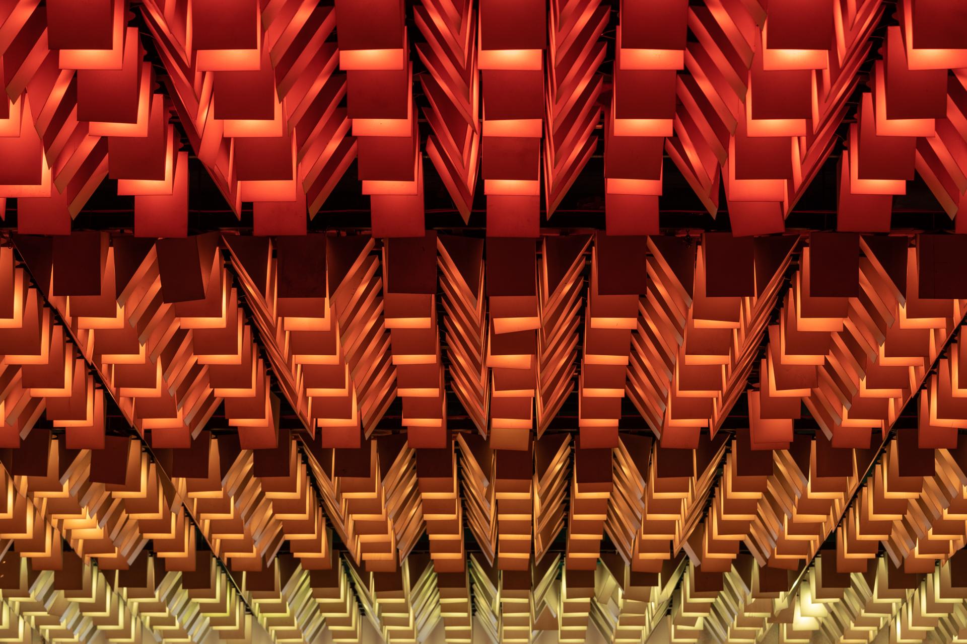 Vibrant ceiling design with geometric patterns and dynamic lighting at New Century, a unique community venue.