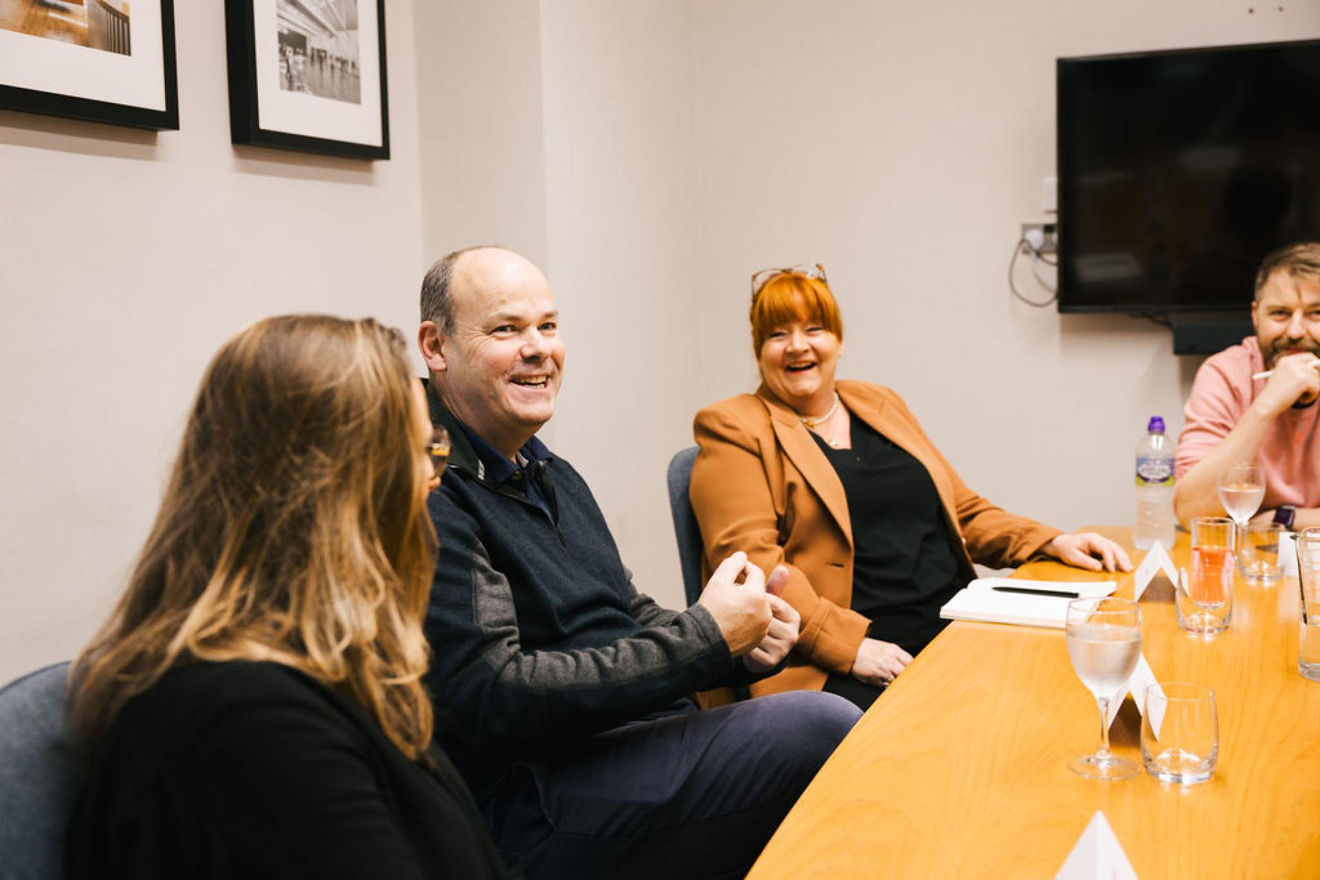 Discussion panel engaged in Glasgow's property outlook with smiling participants and a collaborative atmosphere.
