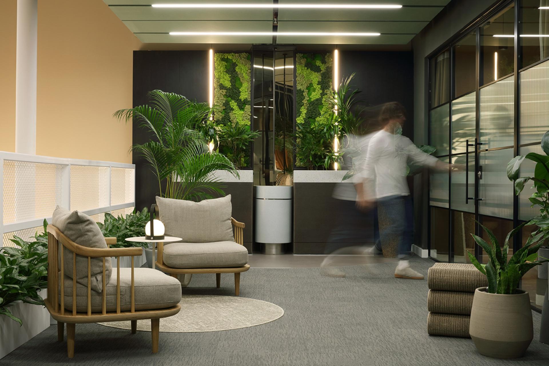 Modern social hub interior at Eden, New Bailey, featuring plants, seating, and sustainable design elements.