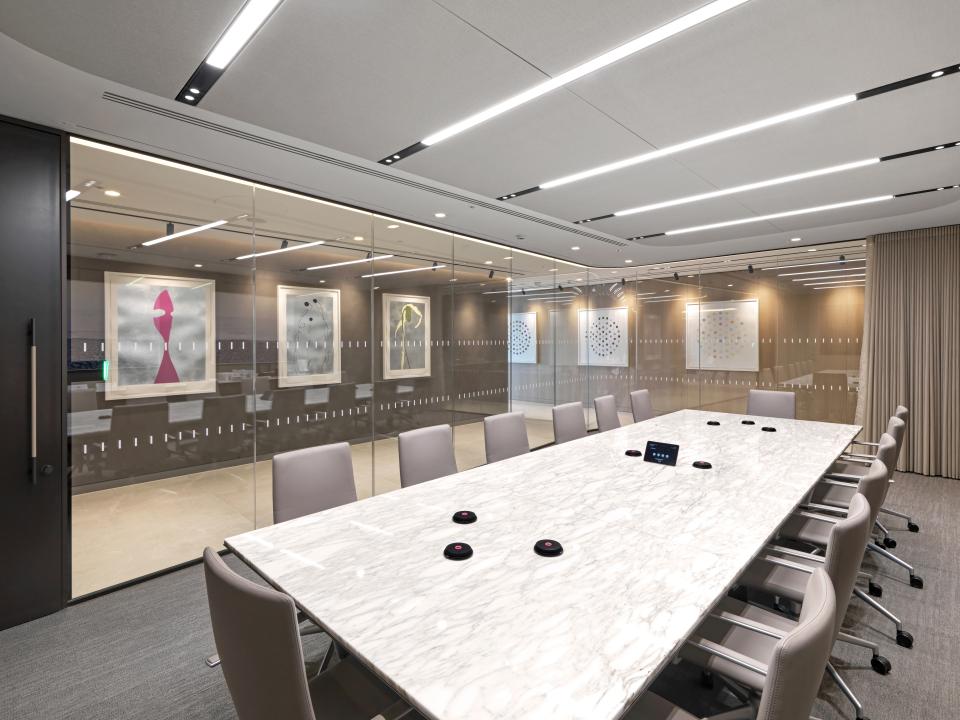 Elegant conference room featuring a marble table, glazed screens, and modern art, showcasing Radii's design for Baker Botts.