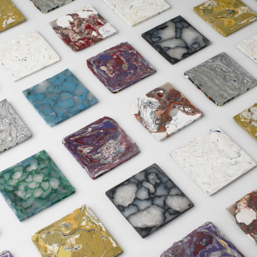 Colorful square tiles with abstract patterns, showcasing innovative materials and designs for the Surface Design Show in London.
