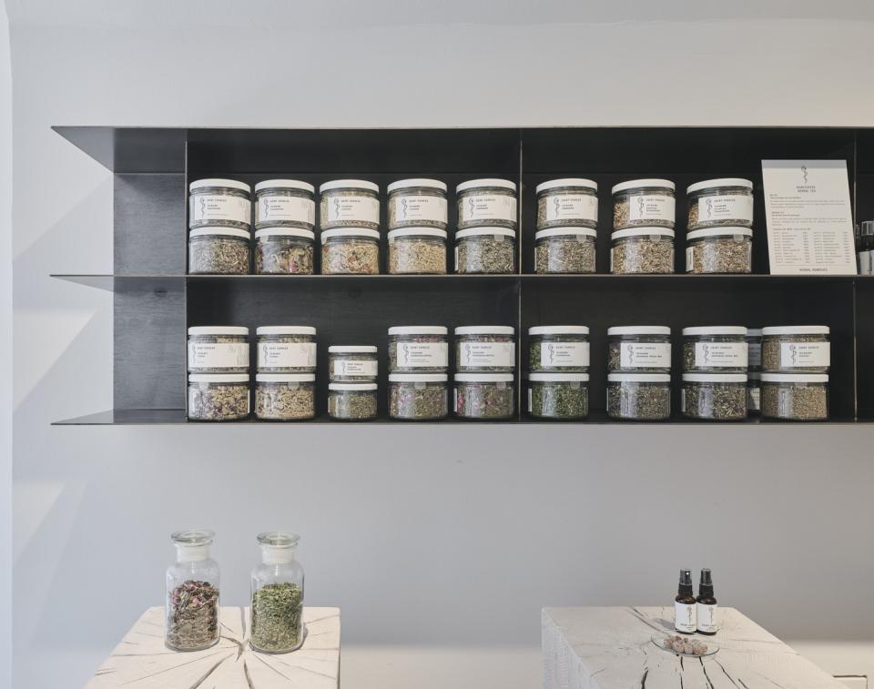 Shelves filled with jars of natural herbs and cosmetics, showcasing Saint Charles' commitment to organic materials in Salzburg.