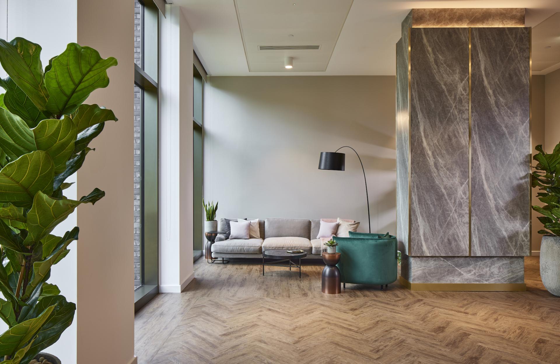 Modern residential amenity space designed by SpaceInvader featuring a cozy seating area and greenery.