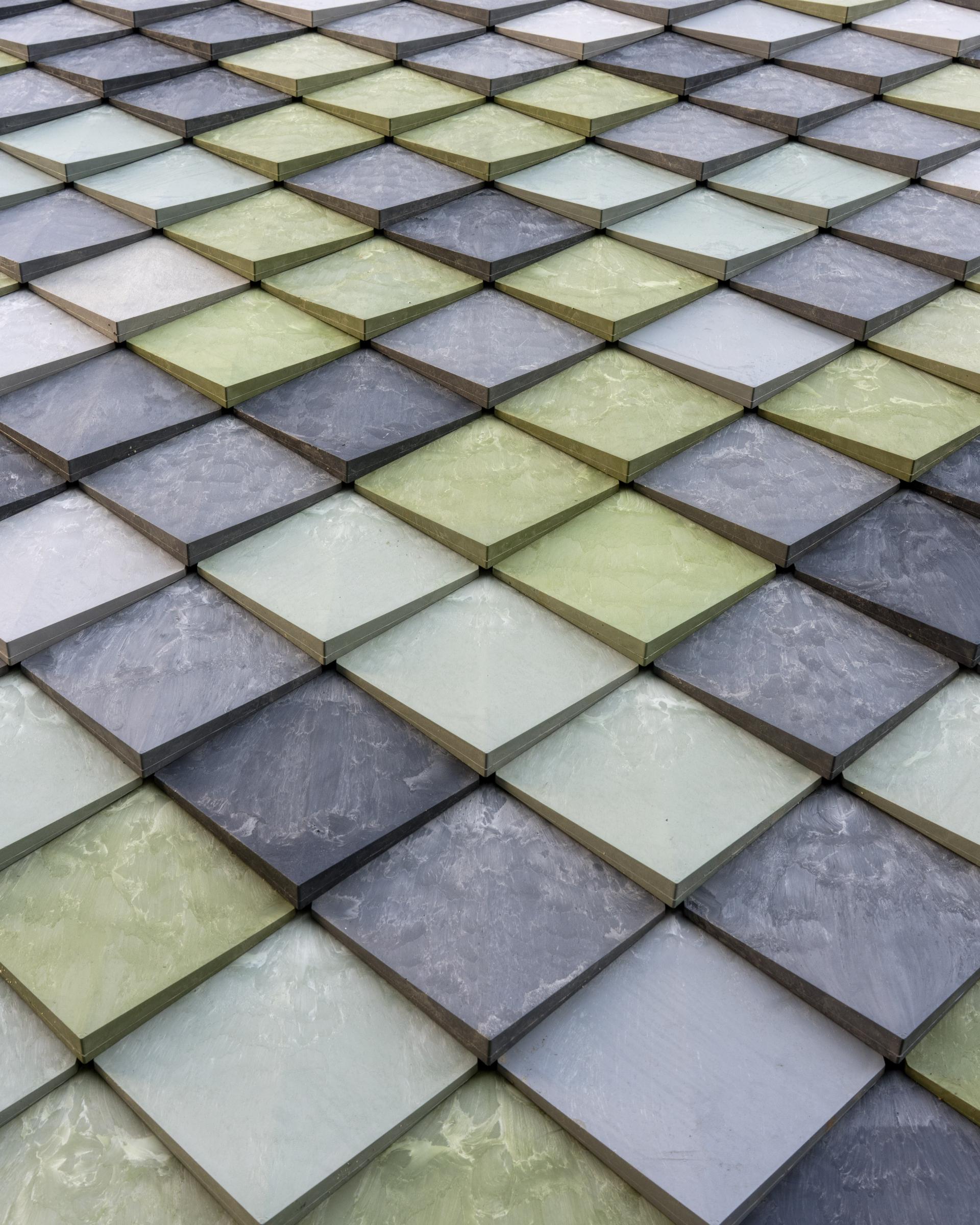 Colorful biomaterial tiles arranged in a geometric pattern, showcasing sustainable design and low carbon building materials.
