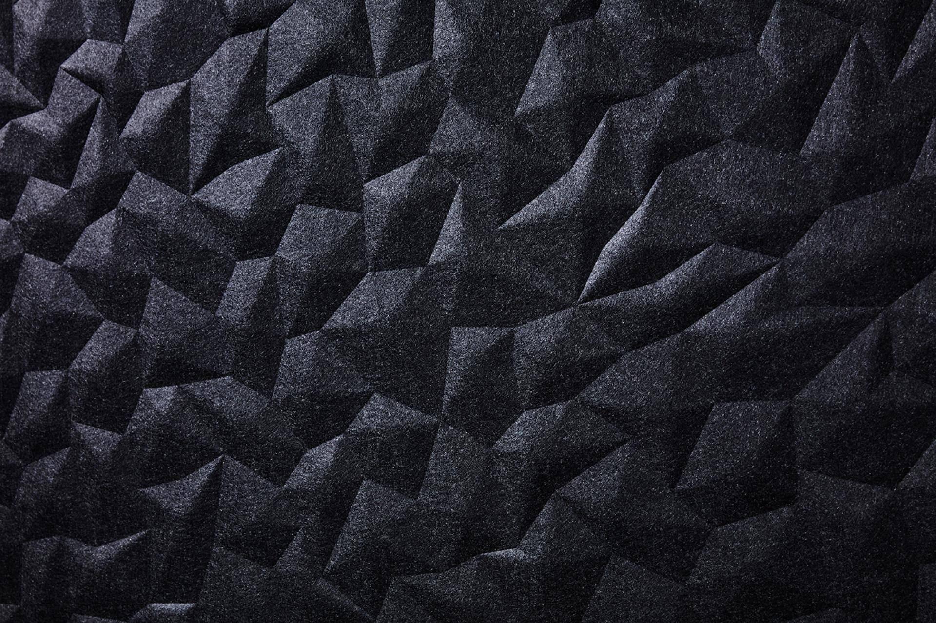 Textured black acoustic wall panel showcasing the innovative design of Woven Image's ION, inspired by Japanese aesthetics.
