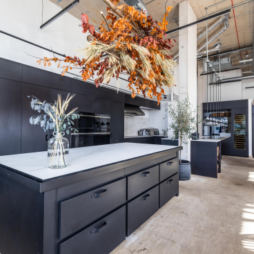 Stylish East London restaurant kitchen featuring Dekton® surfaces, modern cabinetry, and decorative floral arrangements.