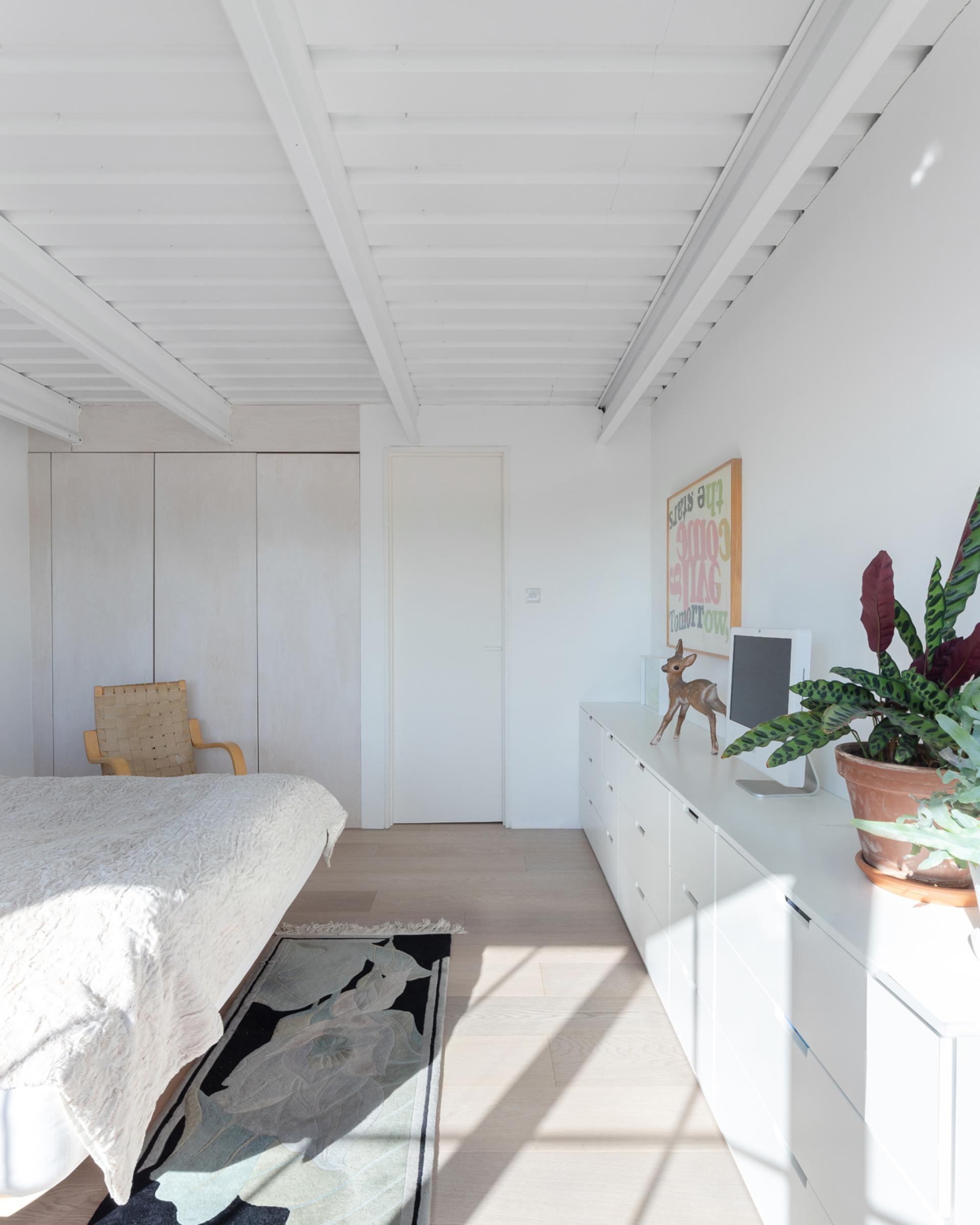 Bright studio flat interior with minimalist decor, showcasing a cozy bedroom, modern furnishings, and natural light.