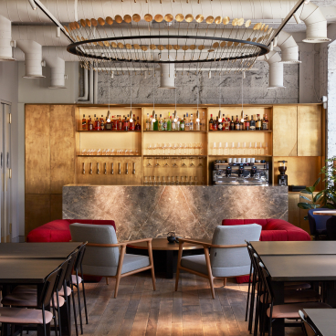 Stylish co-working space featuring a cocktail bar design, with elegant seating and a well-stocked bar in London.