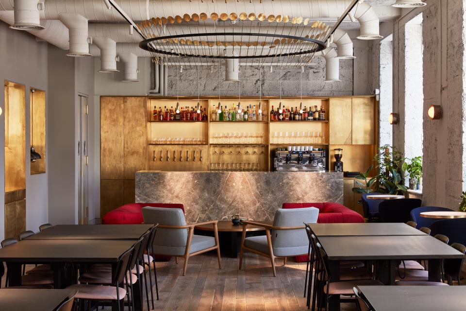 Stylish co-working space featuring a cocktail bar design, with elegant seating and a well-stocked bar in London.