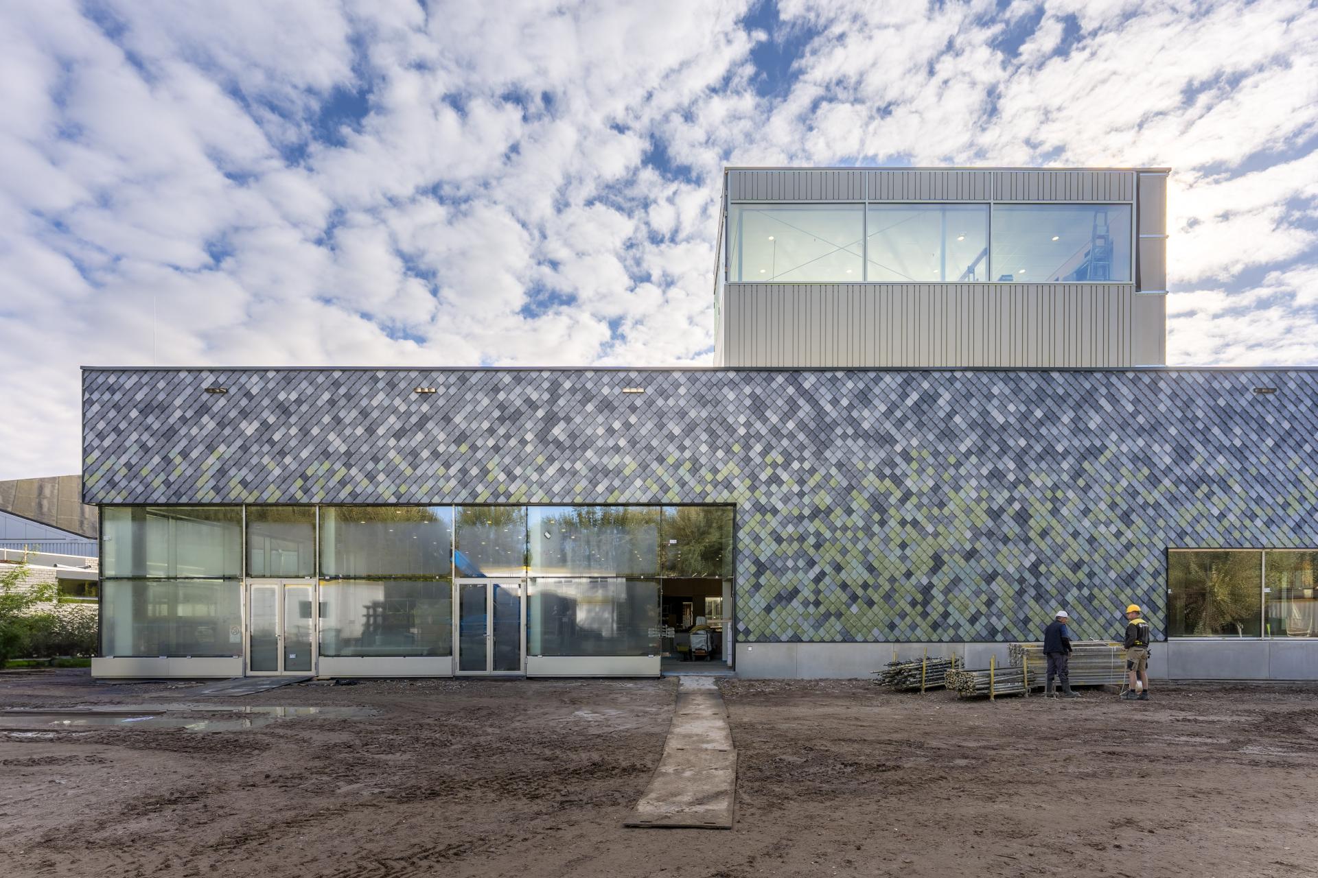 Modern building featuring unique tile facade, representing sustainable construction efforts by Pretty Plastic at Tongelreep National.