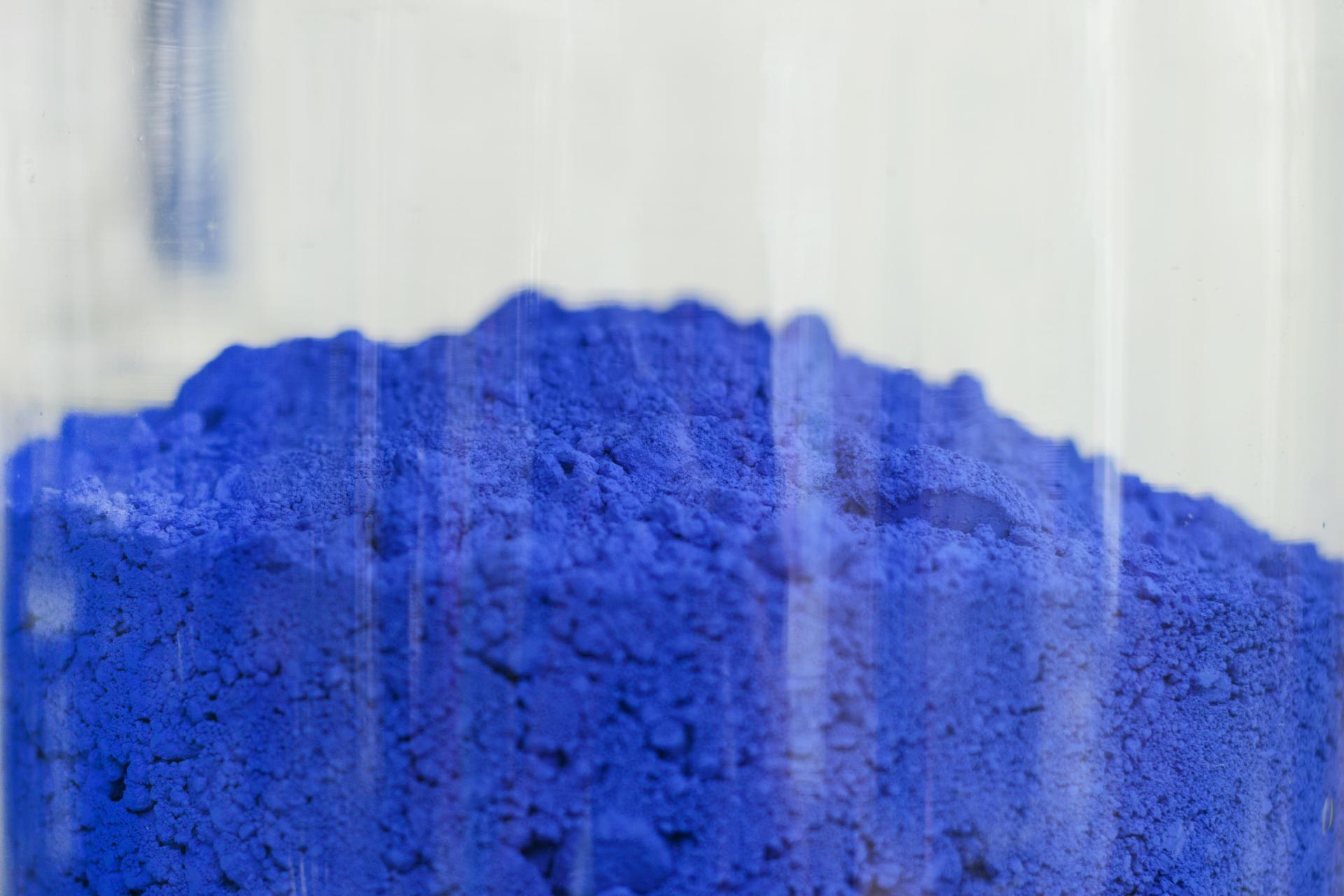 Vibrant blue pigment powder piled up, representing Kvadrat's homage to color in the Divina Melange collection.