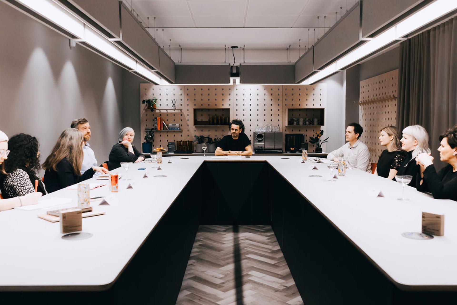 Roundtable discussion on biomaterials and sustainability, featuring diverse participants engaged in conversation in a modern setting.