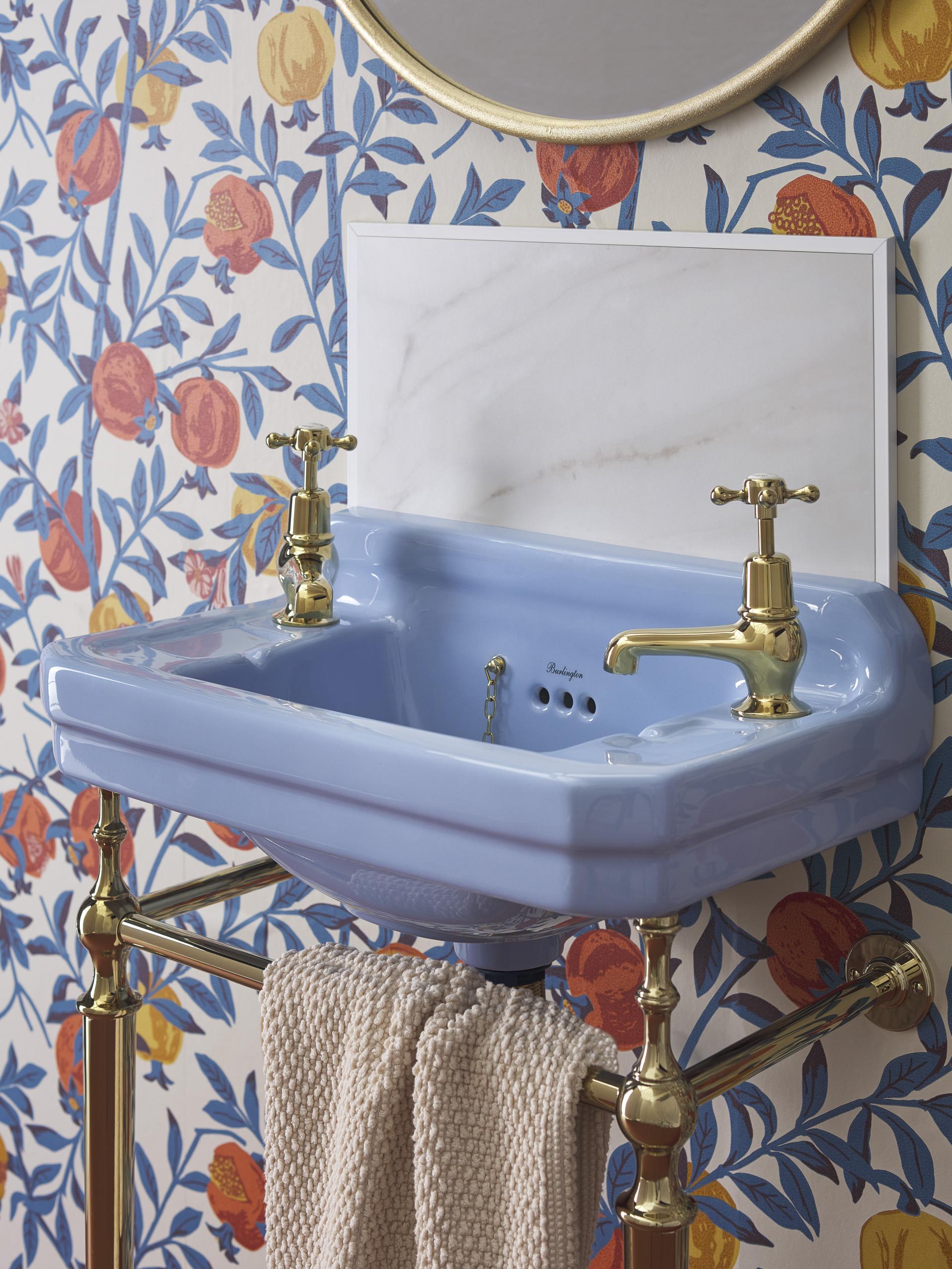 Bespoke ceramic sink in Enchanted Blue, featuring brass faucets and floral wallpaper, showcasing Burlington's new colour collection.