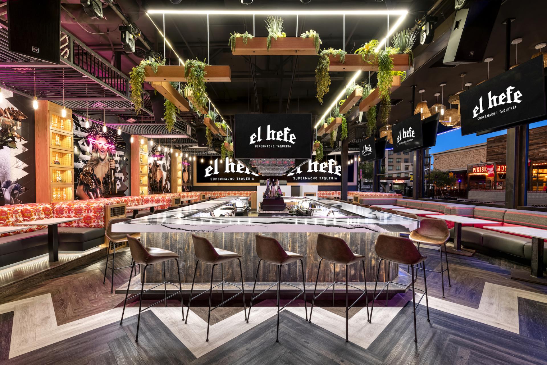 Vibrant interior of El Hefe Supermacho Taqueria showcasing stylish bar seating and modern decor for Instagram-worthy experiences.