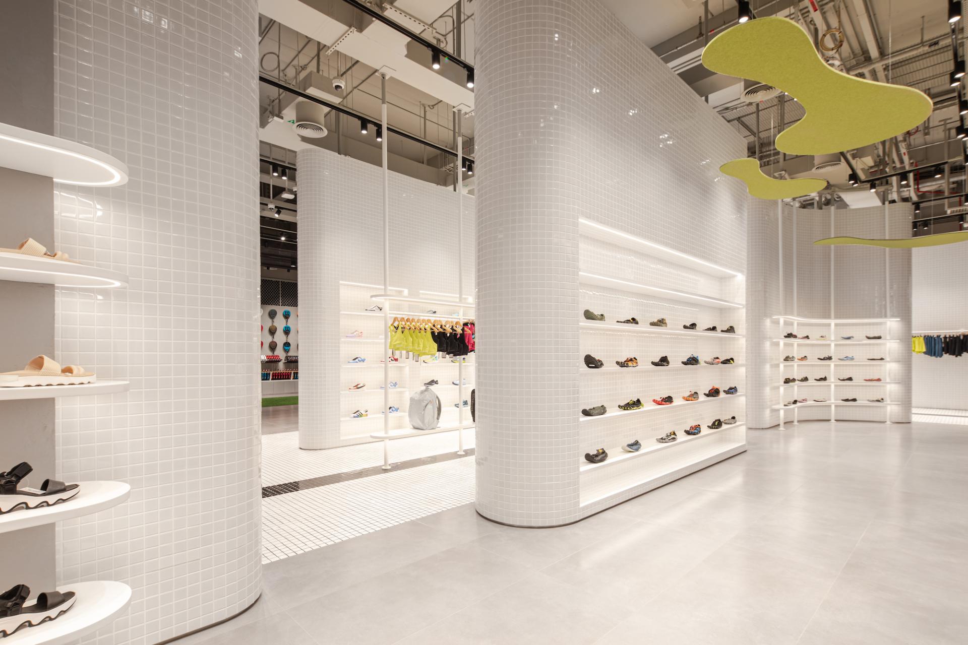 Brightly lit indoor retail space featuring vibrant activewear shoes and apparel displays in a modern concept store.