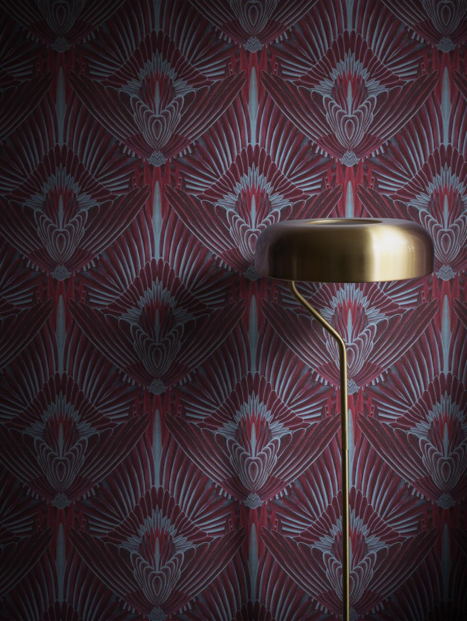 Luxurious burgundy wallpaper with intricate art deco patterns and a stylish brass lamp, showcasing Divine Savages' glamorous design aesthetic.