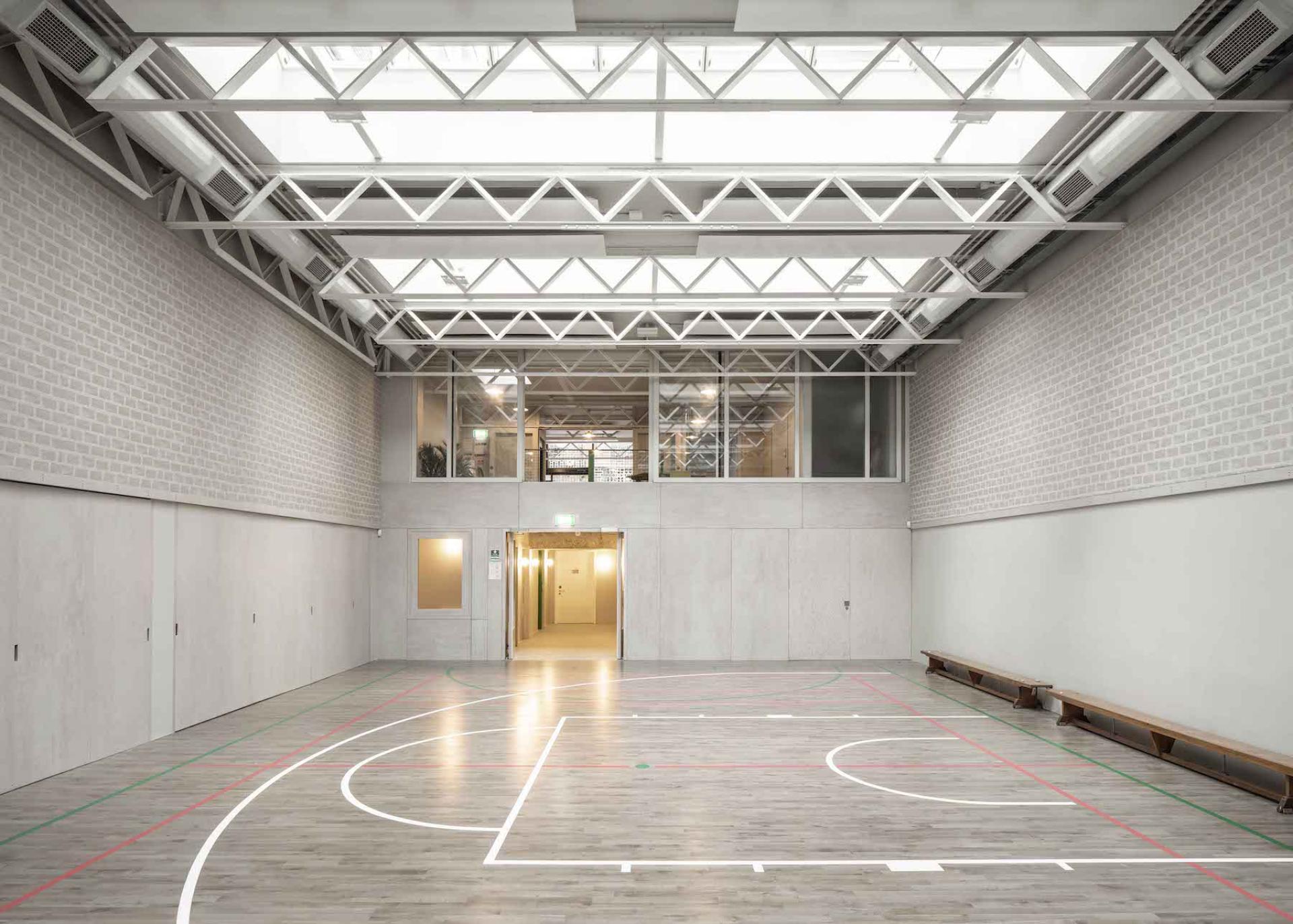 Modern sports hall featuring sustainable design, natural light, and open space, highlighting RIBA's Reinvention Award for retrofitting.