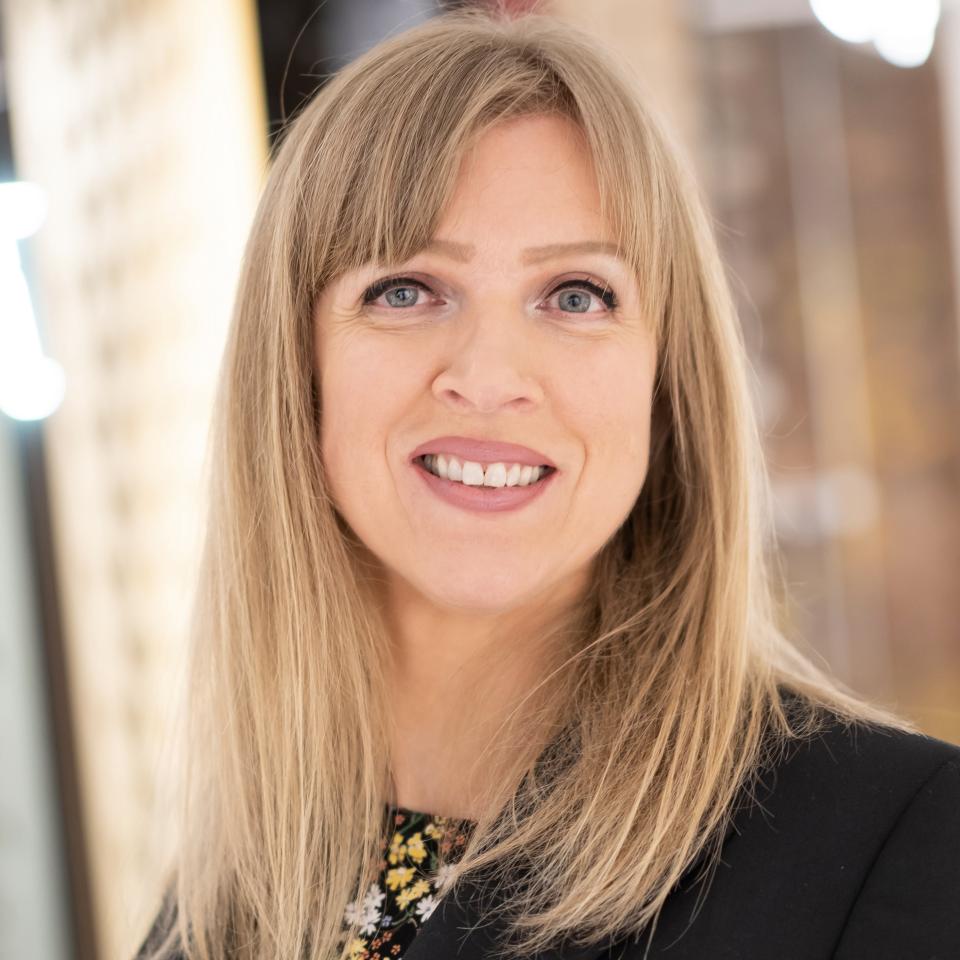 Marion Room, DMWR Architects, smiling warmly in a professional setting, illustrating innovation in architectural design conversations.