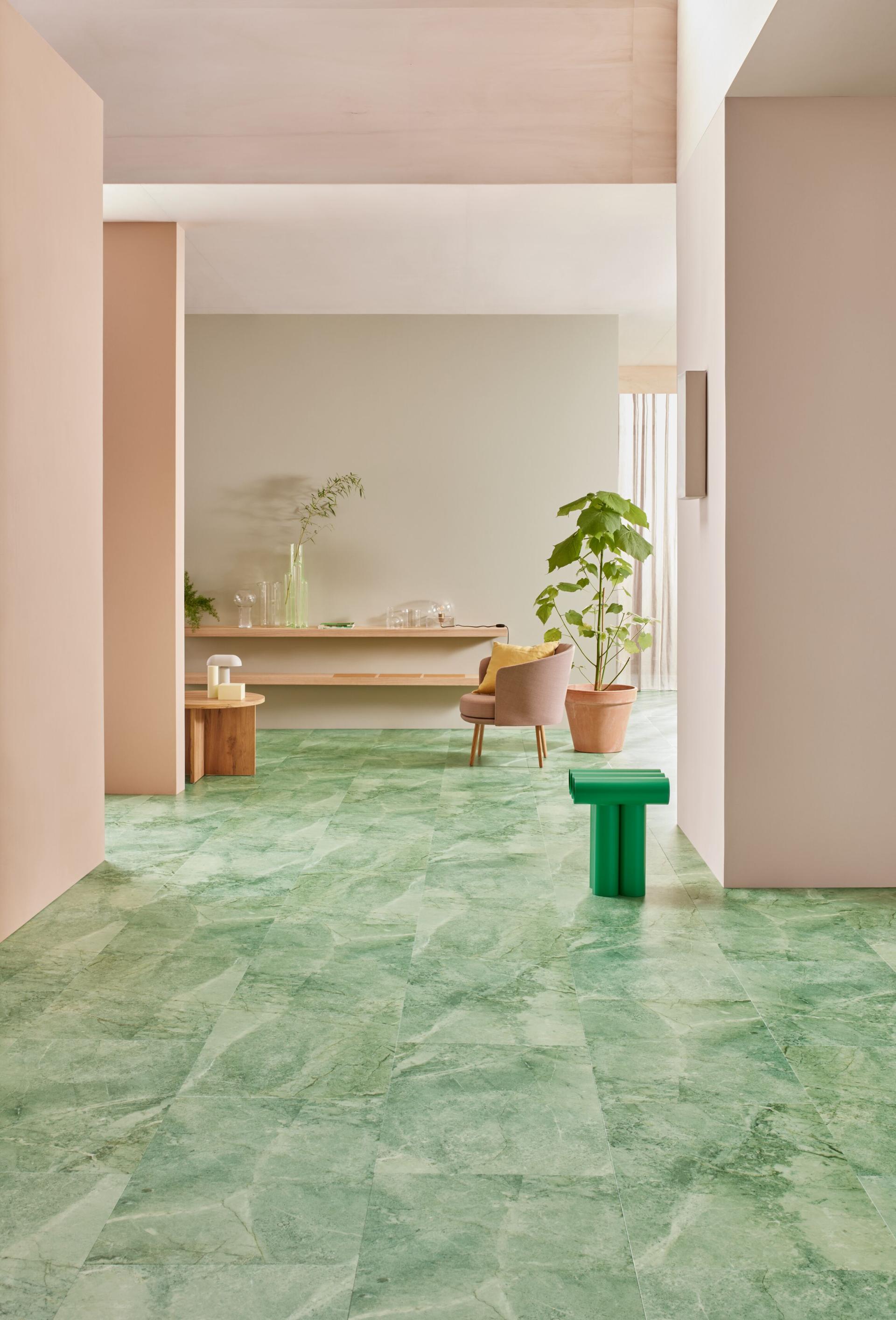 Luxurious green vinyl flooring from Forbo's Allura Decibel collection enhances a serene, modern interior space.