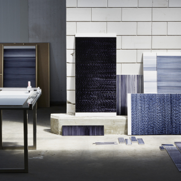 Innovative tile designs by Léa Mazy displayed on a table, showcasing a new printing process for the tile industry.