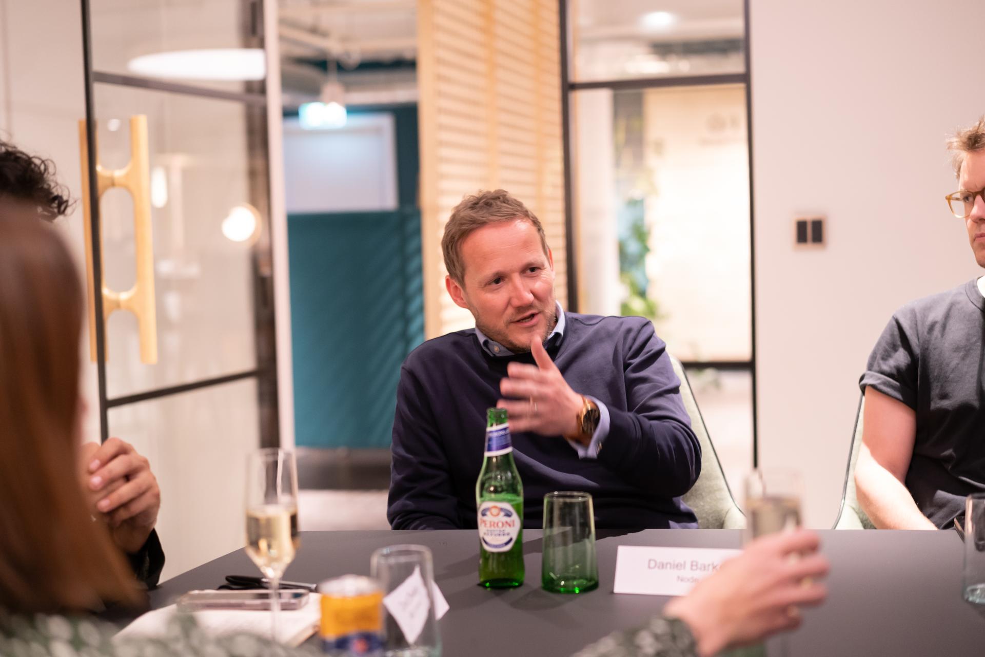 Discussion at a technology seminar, featuring a speaker engaged in dialogue with participants in a modern workspace.