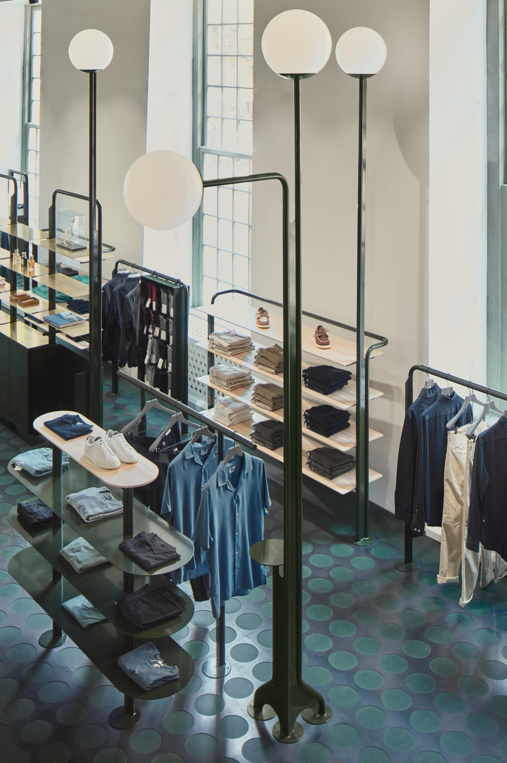 Modern clothing display featuring stylish apparel and unique lighting design at the COEF shop in Utrecht.