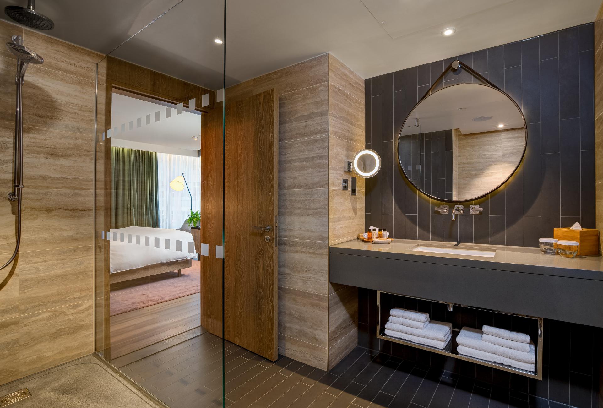 Vegan hotel suite bathroom featuring modern design, plant-based materials, and a stylish sink area with towels.