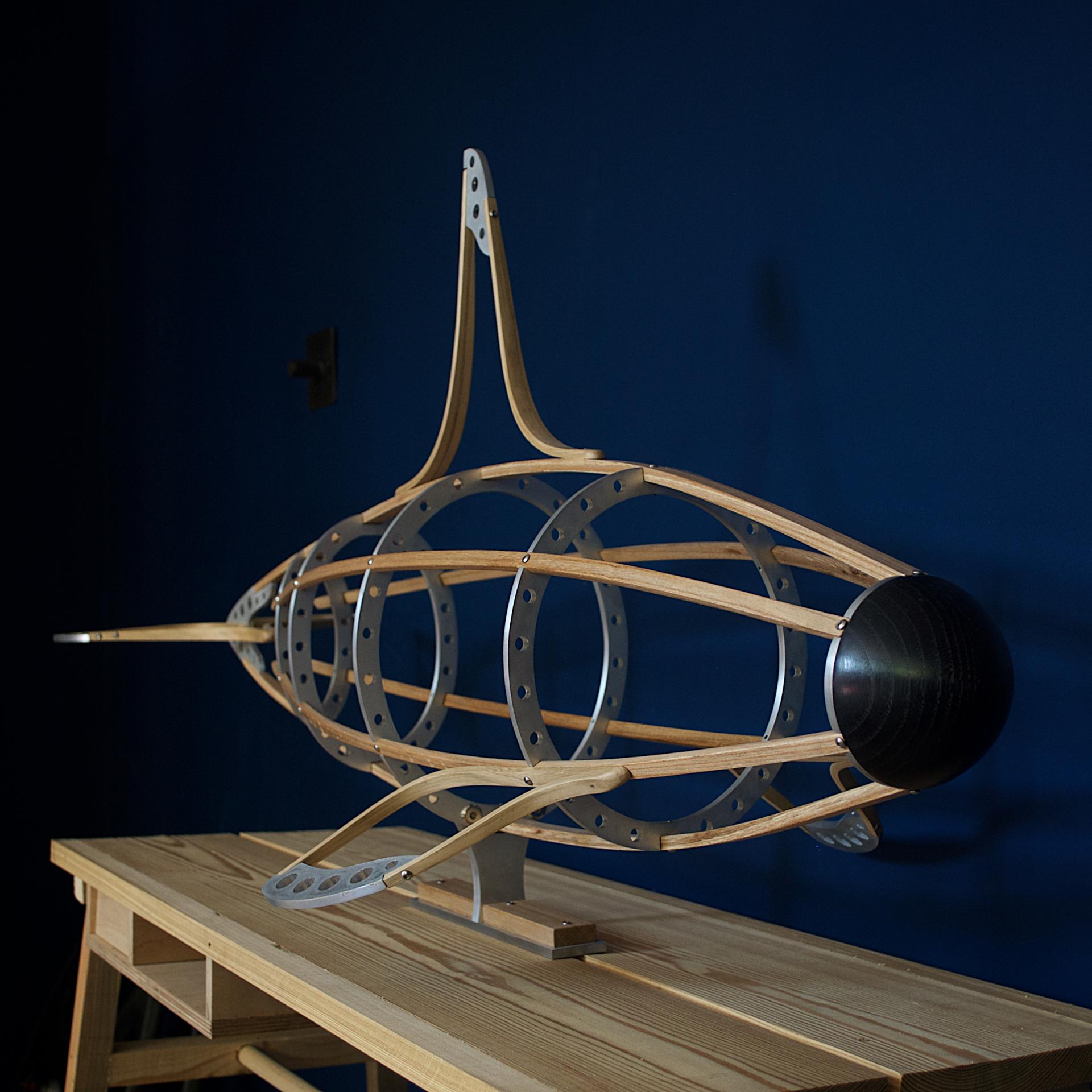 Sculptural model of a contemporary submarine design showcasing sustainable materials and craftsmanship in Sandy's workshop.