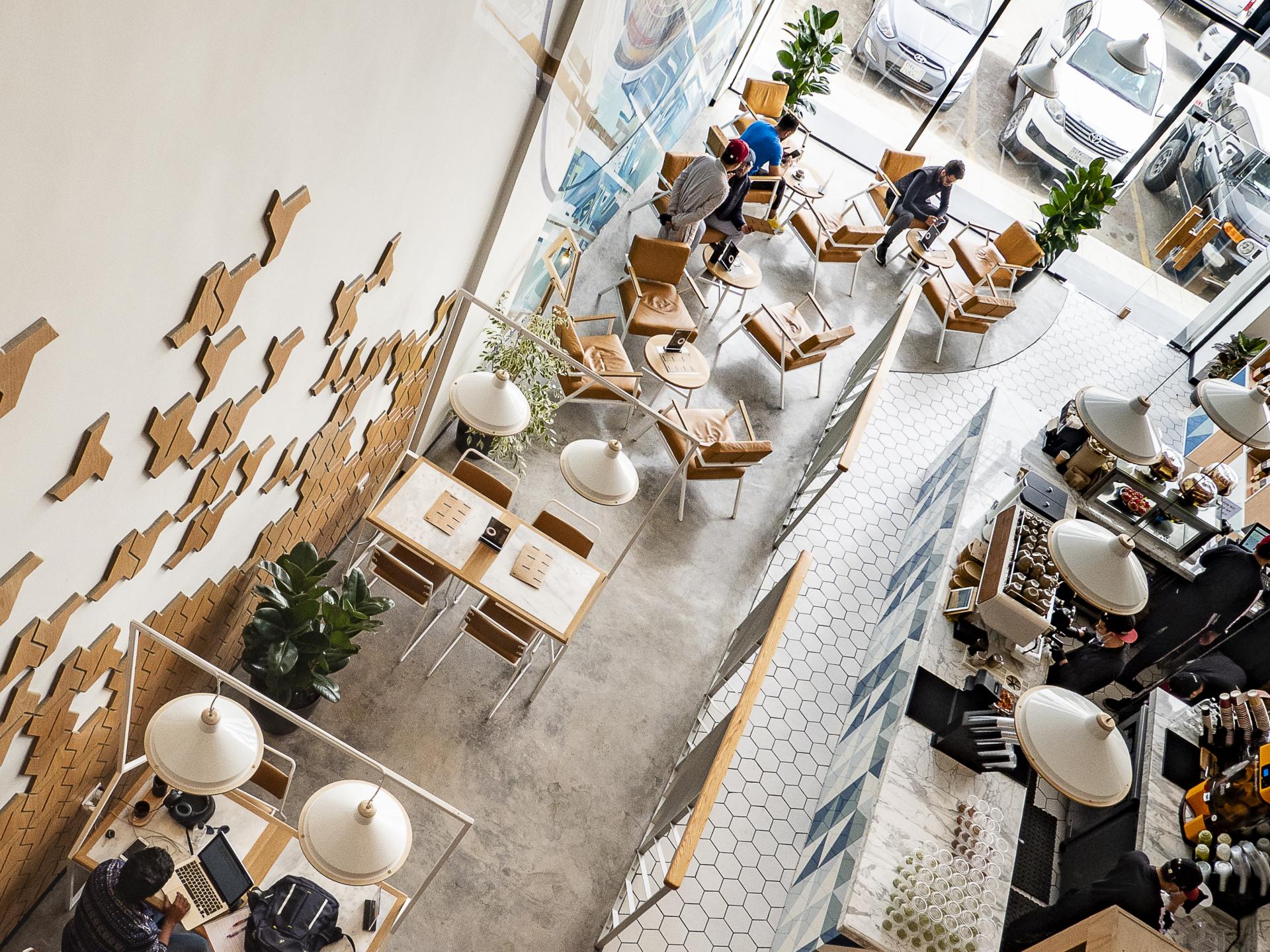 A stylish coffee shop interior featuring modern furniture, customers engaging, and an artfully designed atmosphere.