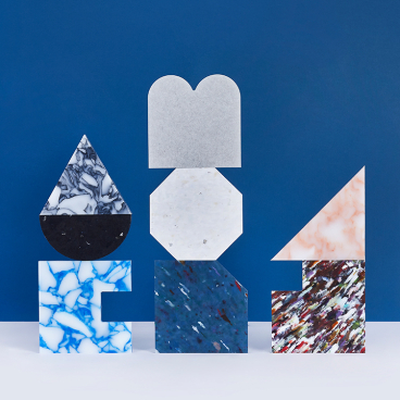Colorful geometric shapes made of materials displayed against a deep blue background, showcasing design creativity and innovation.