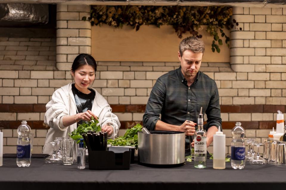 Two participants preparing ingredients at Material Source Studio's celebration event, showcasing community engagement and creative collaboration.