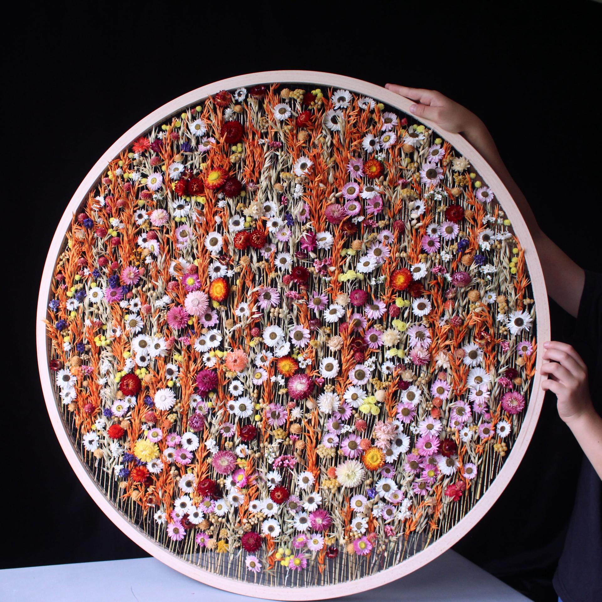 Colorful circular wall art featuring dried flowers, exhibited at London Craft Week 2024, showcasing innovative craft techniques.