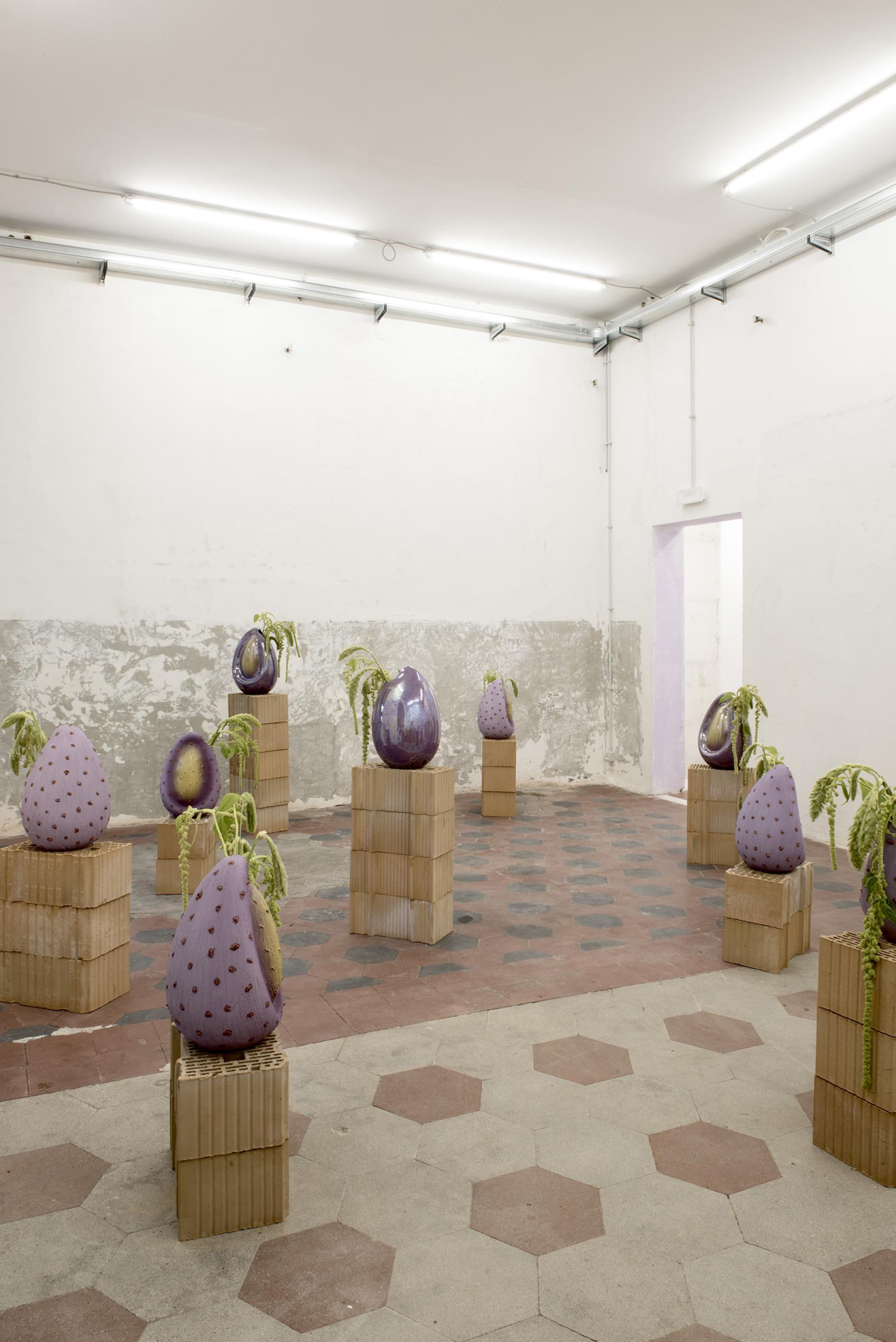 Contemporary art installation featuring unique sculptural pieces on wooden pedestals inside Palazzo Brancaccio, Rome.
