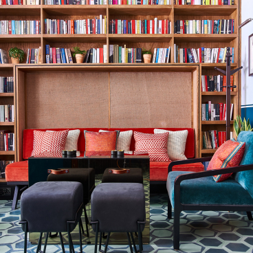Stylish art deco interior of Teatulia’s tea shop, featuring colorful seating, book shelves, and geometric floor tiles.