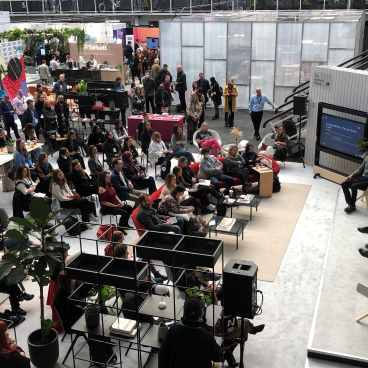 Crowd gathered at Workspace Design Show 2023, featuring discussions on innovative workspace design and sustainability.