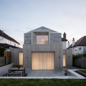 Modern hipped house design by Oliver Leech Architects features a blend of natural materials and serene outdoor living space.