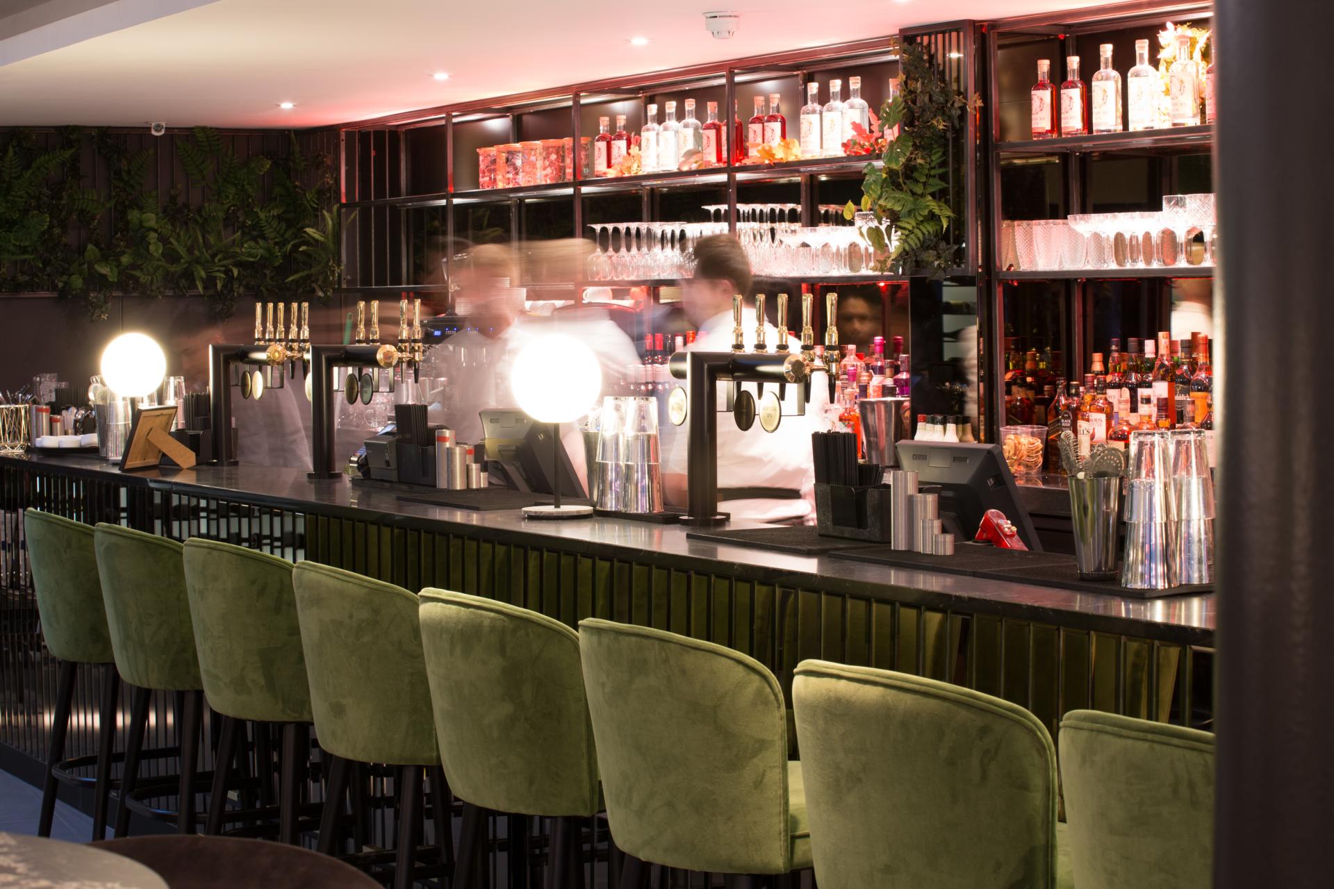 Elegant bar area in Albert's Didsbury, showcasing stylish seating and a vibrant selection of spirits.